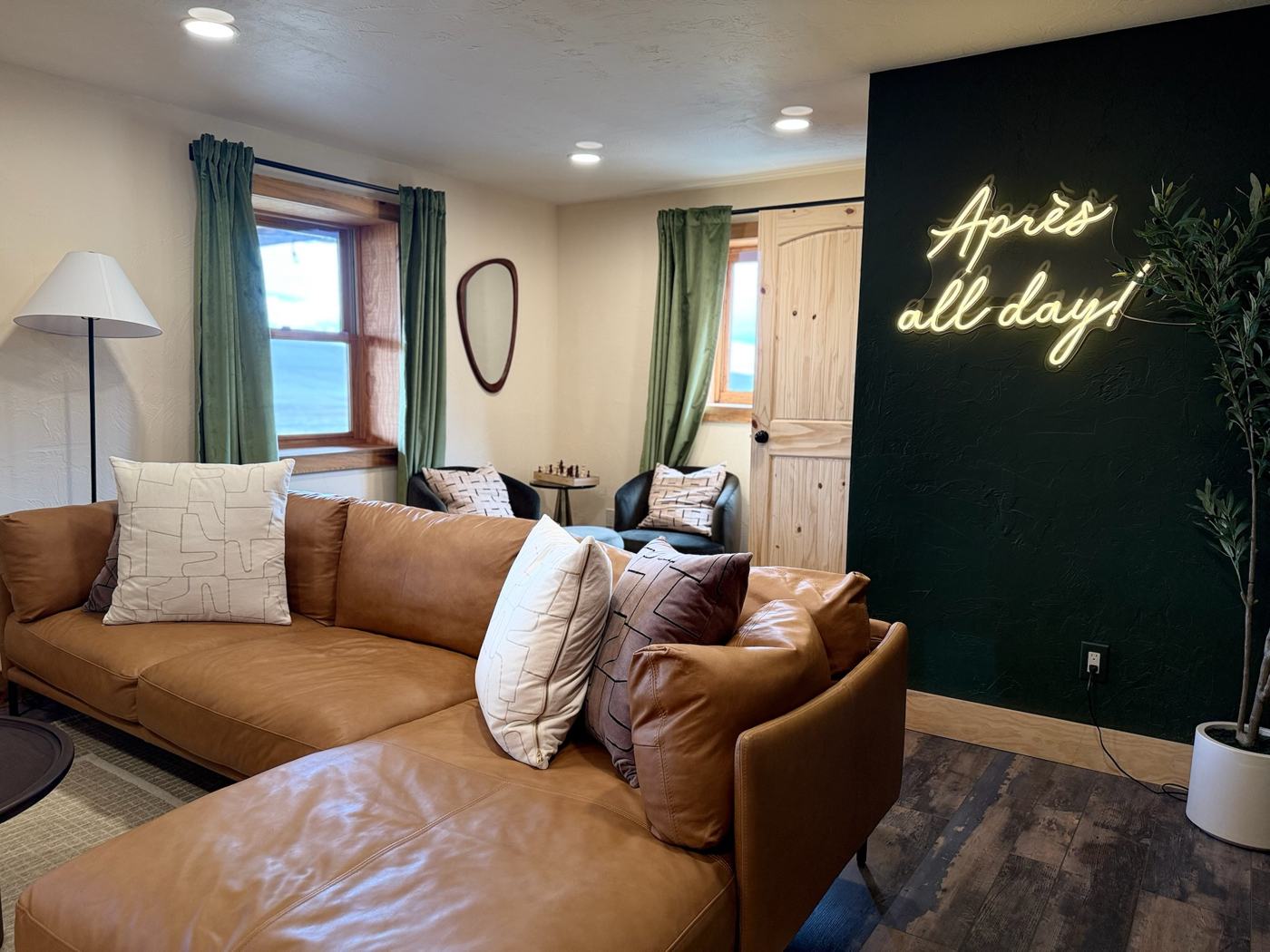 Après lounge with neon sign and caramel leather sectional