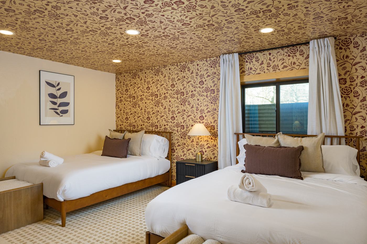 Guest bedroom with two queen beds and floral wallpapered ceiling